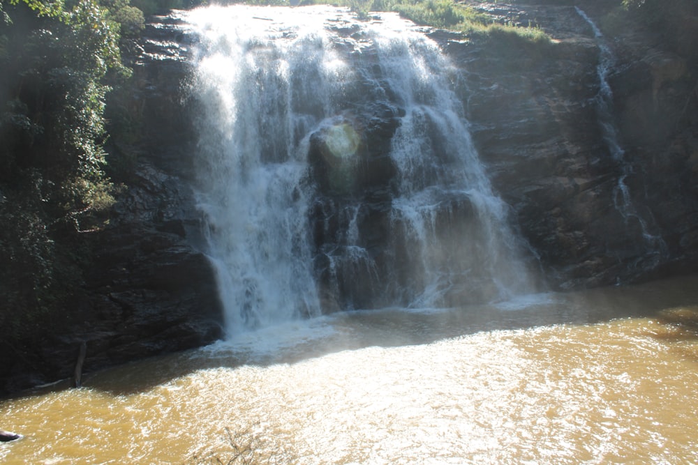 a man standing in front of a waterfall