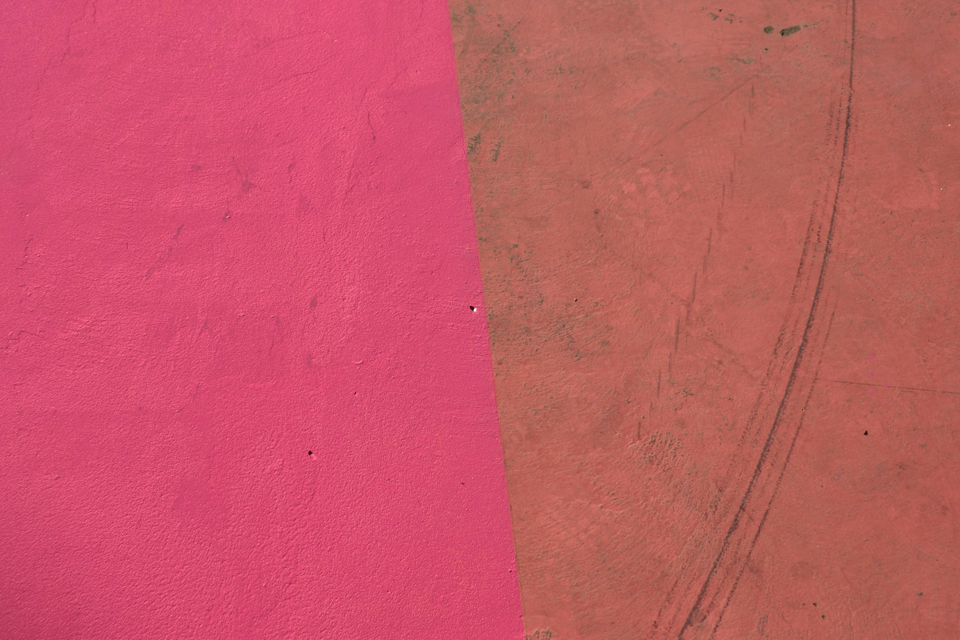 a red and a pink wall with a skateboard on it