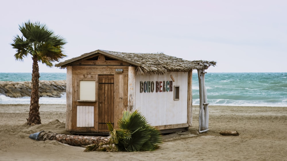 una piccola baracca seduta in cima a una spiaggia sabbiosa