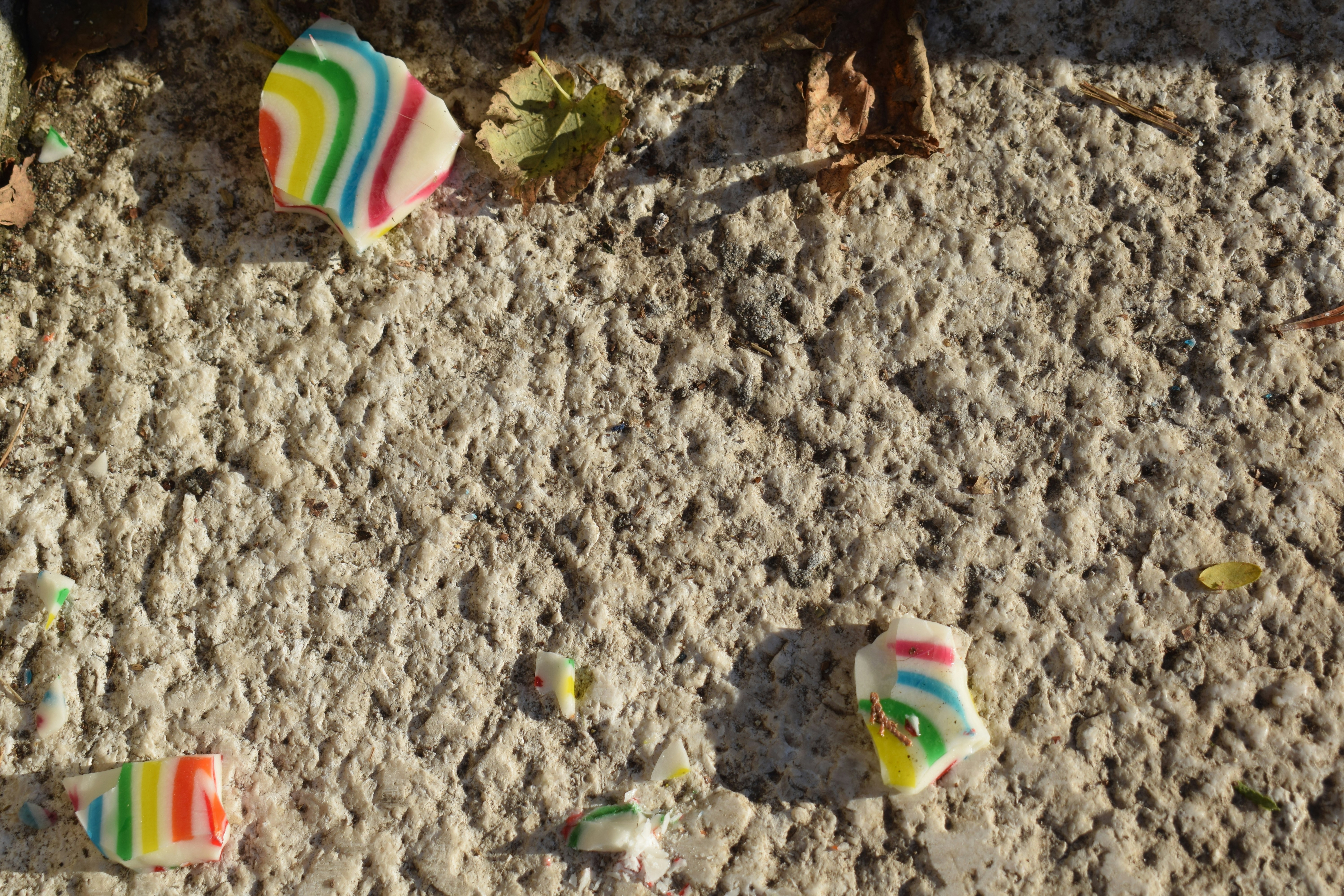 A group of candy candies sitting on top of a sandy ground photo Free