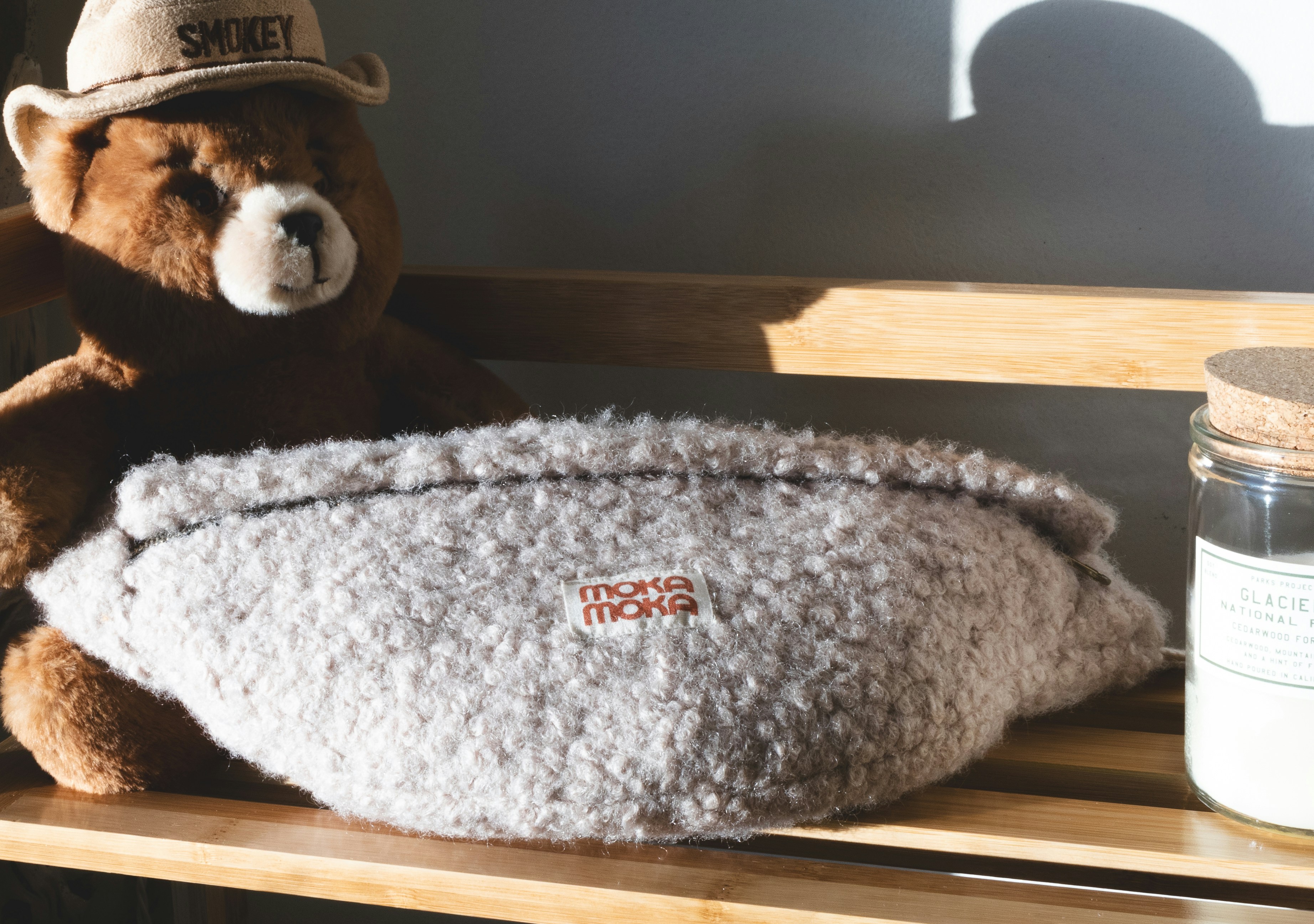 a brown teddy bear sitting on top of a wooden shelf