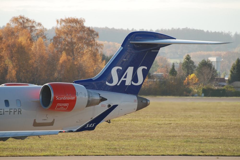 a blue and white airplane is on a runway