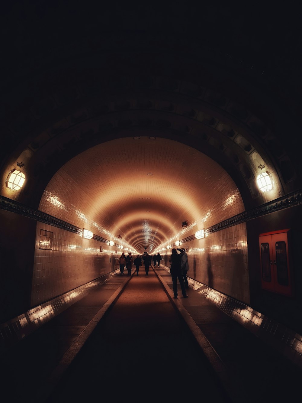 a group of people walking through a tunnel