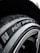 A close-up view of a car tire with the text 'Pilot Sport' clearly visible on the sidewall. The tire texture and tread details are prominent, set against a dark background that showcases the metallic sheen of the rim.