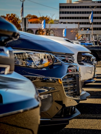 A fleet of company vehicles lined up, freshly cleaned and gleaming under office building lights.