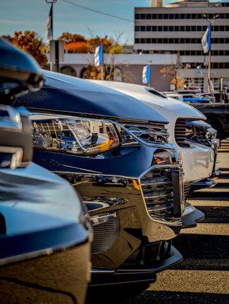 A business fleet of clean, polished vehicles lined up in front of an office building