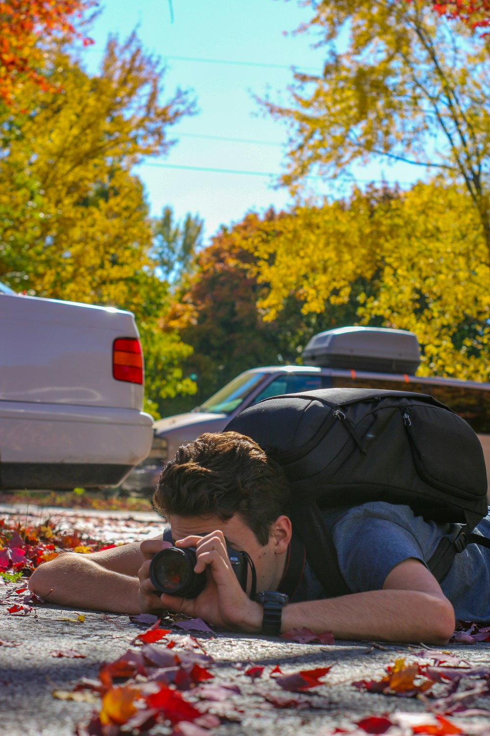 a man laying on the ground with a camera