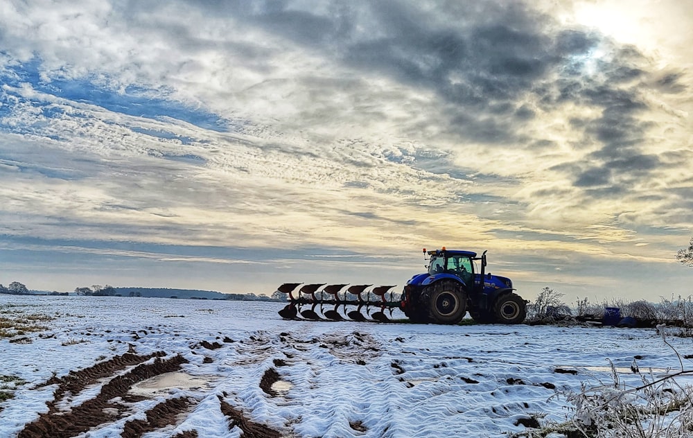 a tractor is pulling a plow through a snowy field