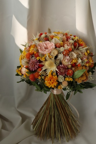 a bouquet of flowers sitting on top of a white sheet