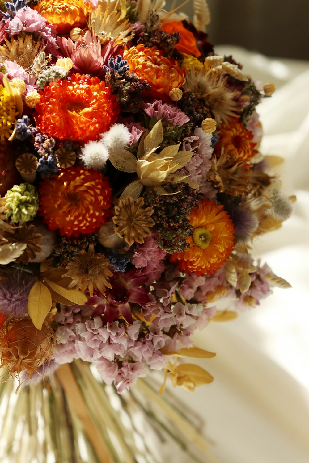 a bridal bouquet of dried flowers on a bed