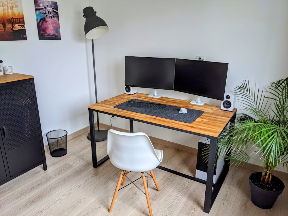 a computer desk with two monitors and a keyboard