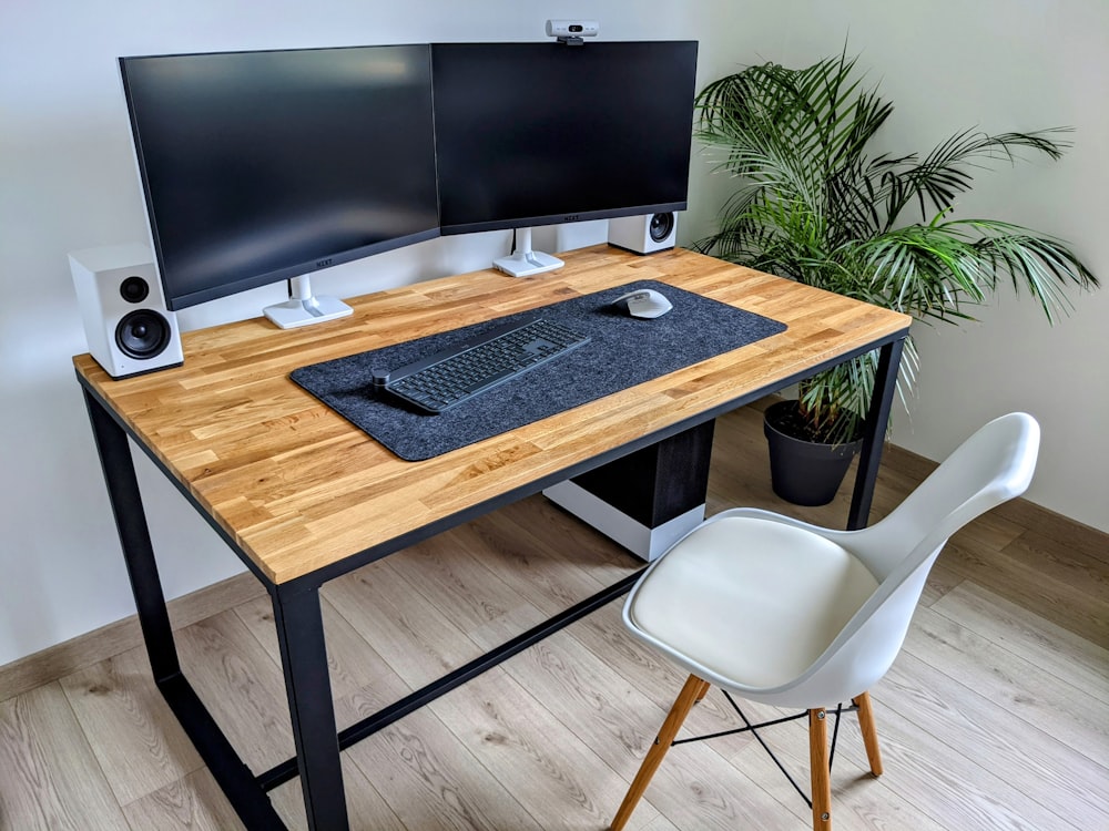 a computer desk with two monitors and a keyboard