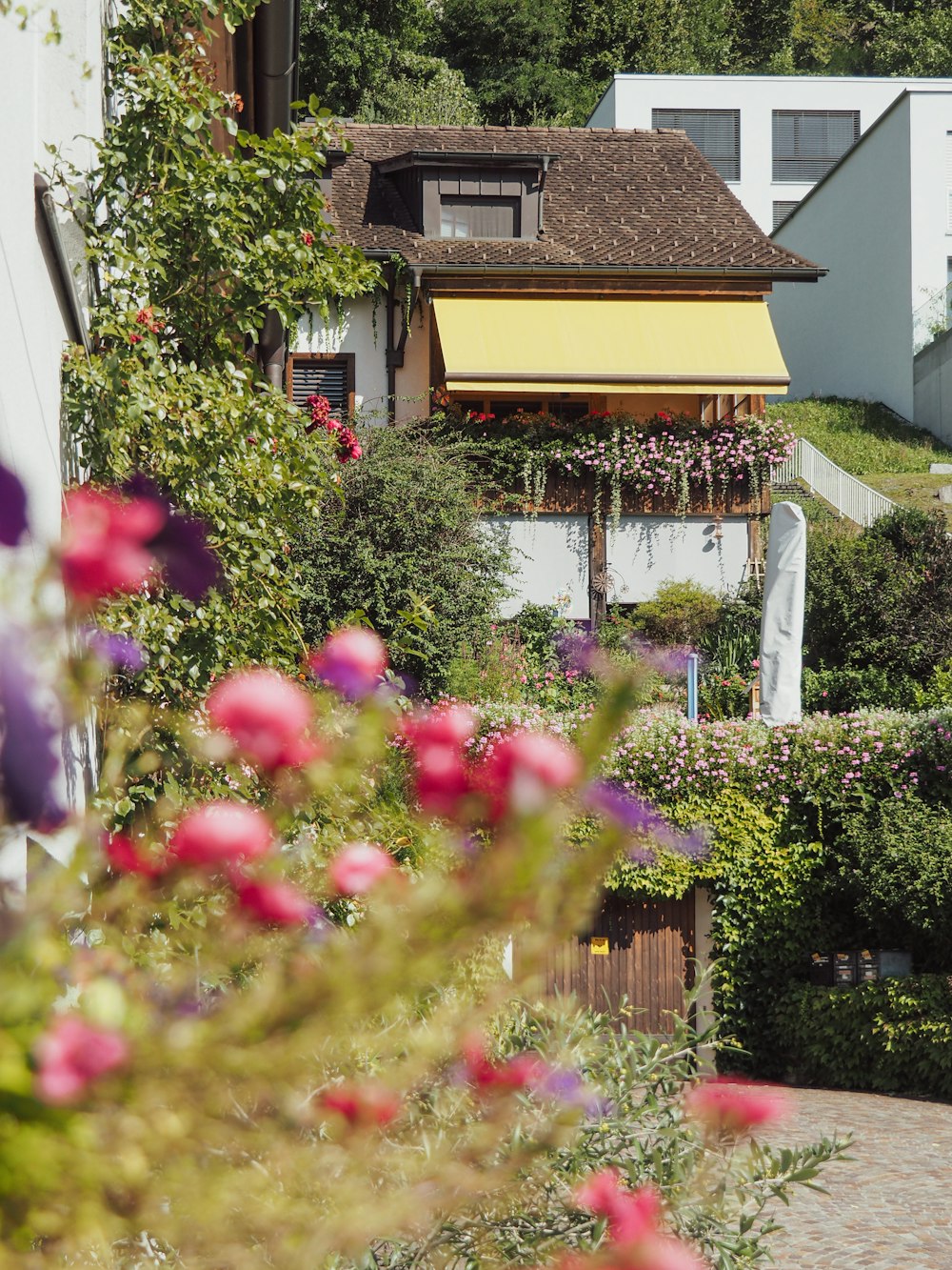 a house with a yellow awning next to a garden