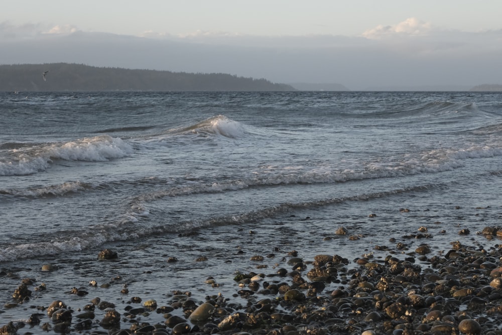 a rocky beach with waves coming in to shore