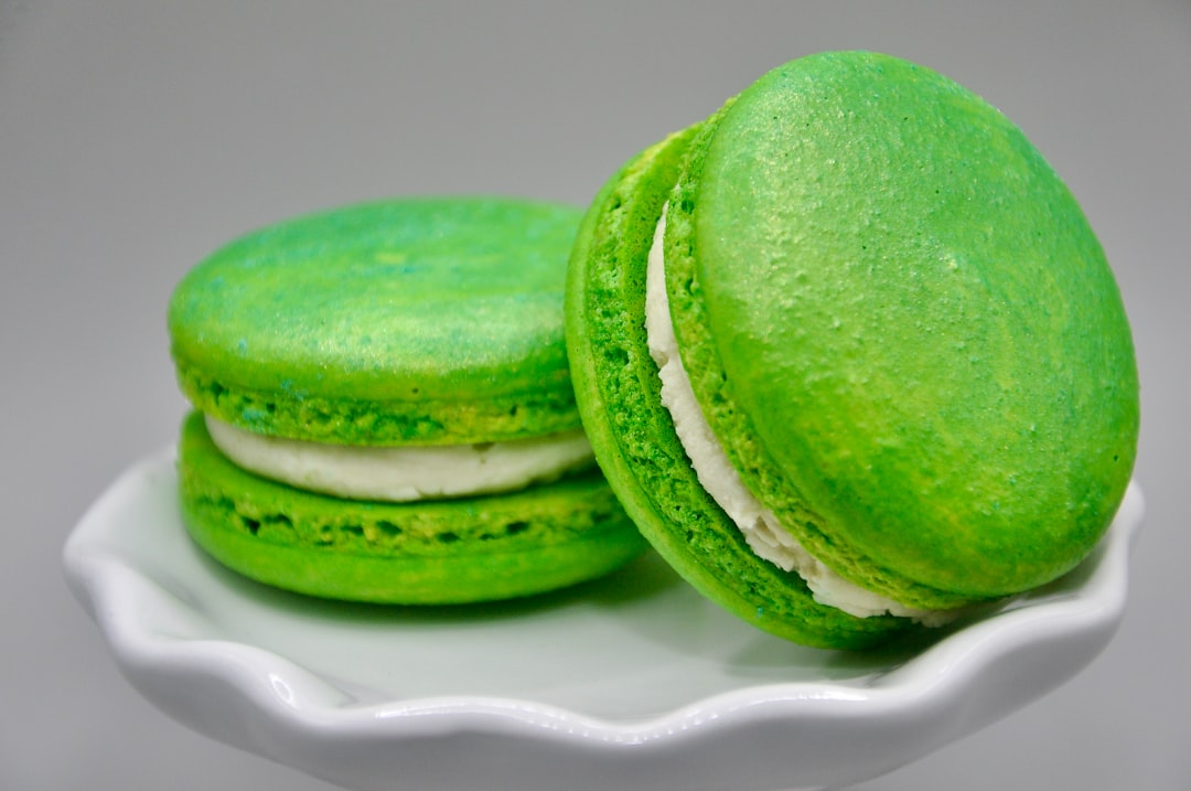 two green macaroons on a white plate, Pistachio White Chocolate Macarons