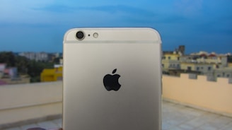 A modern smartphone displayed on a sleek table with a blurred cityscape in the background.