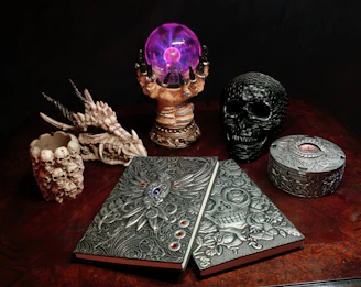 a wooden table topped with a book and a skull