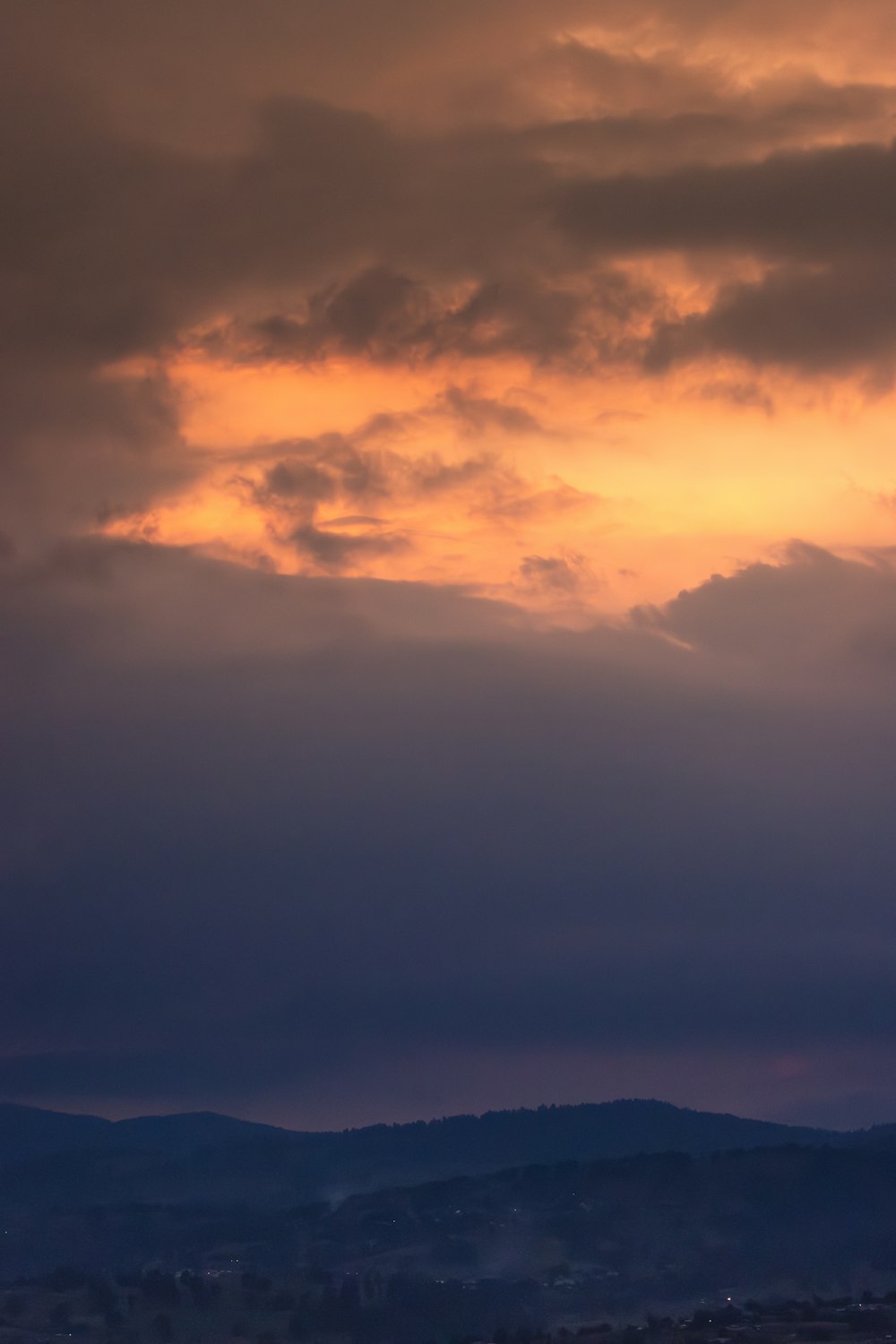 a plane flying in the sky with a sunset in the background