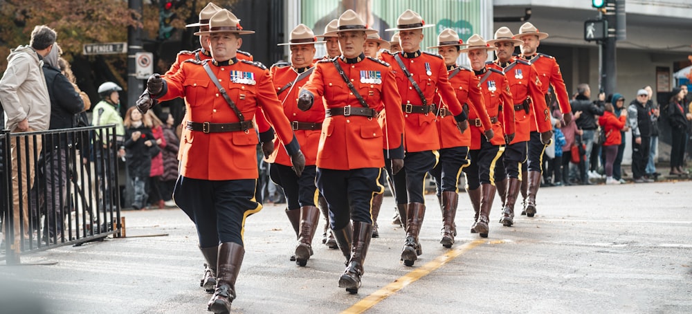 a group of men in red uniforms marching down a street