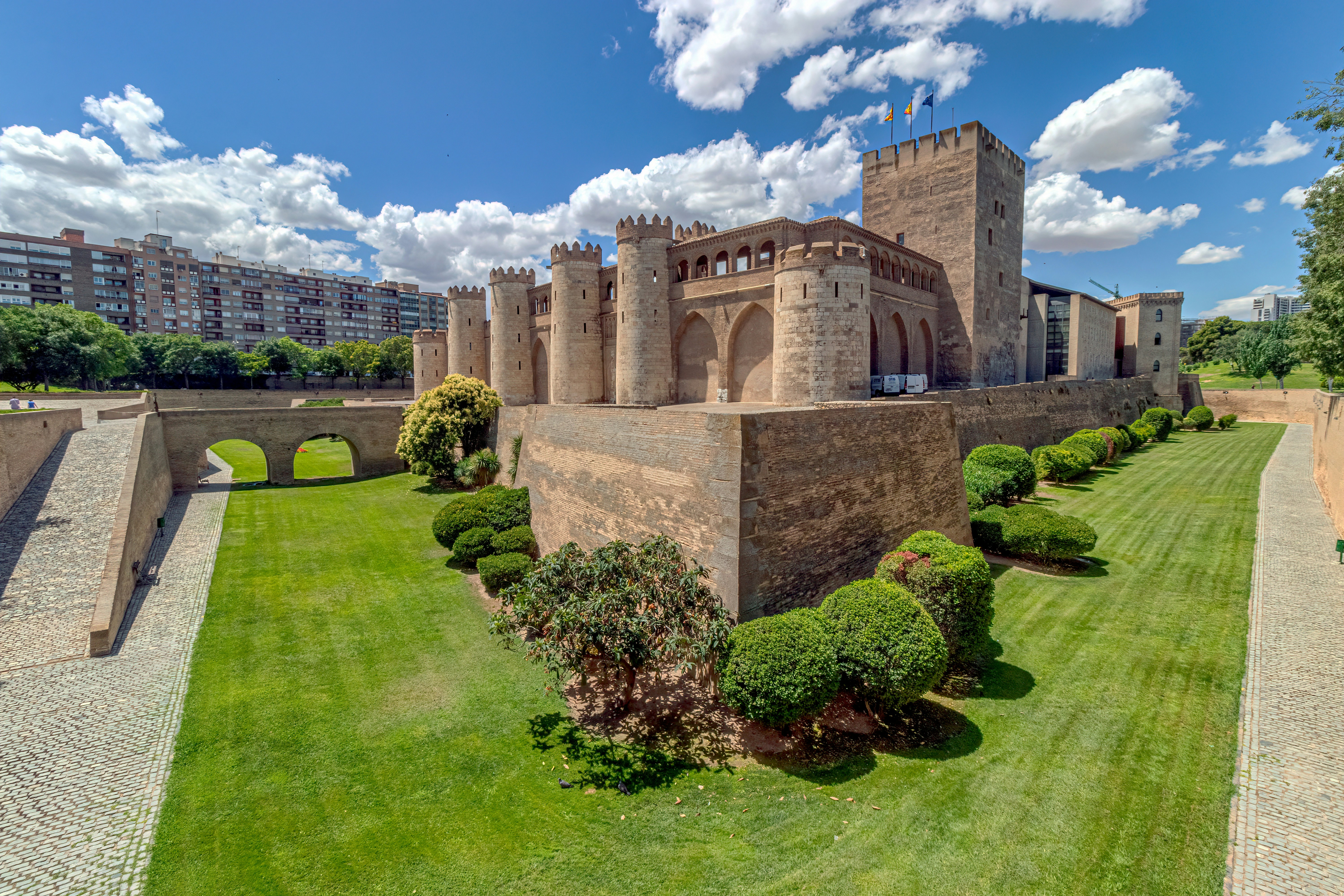 a large castle like building sitting on top of a lush green field