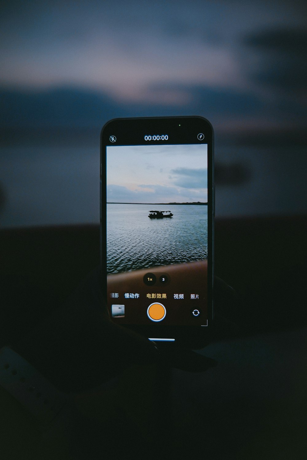 a person taking a picture of a boat in the water
