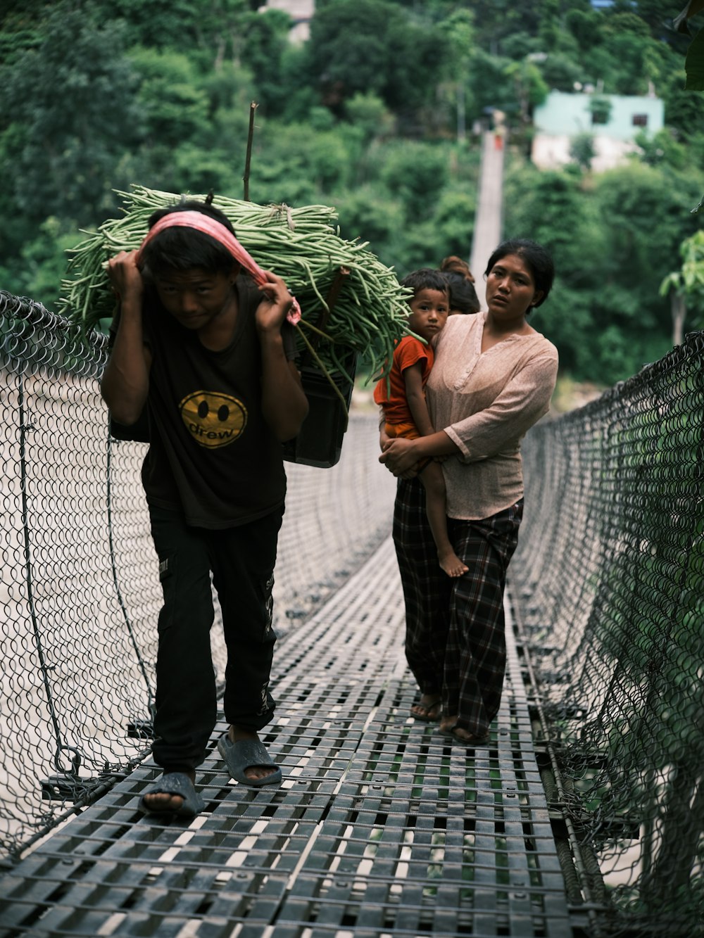 a group of people walking across a bridge