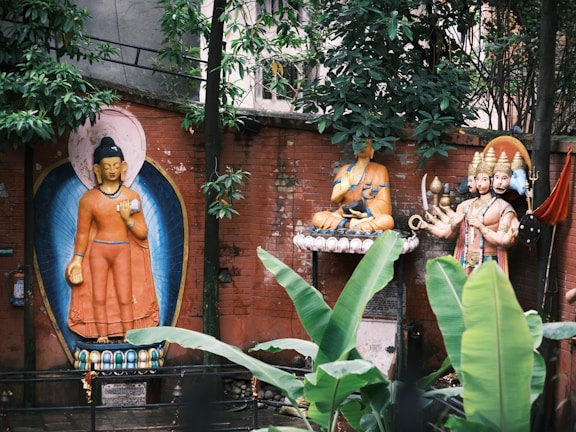 A peaceful courtyard with greenery and religious statues.