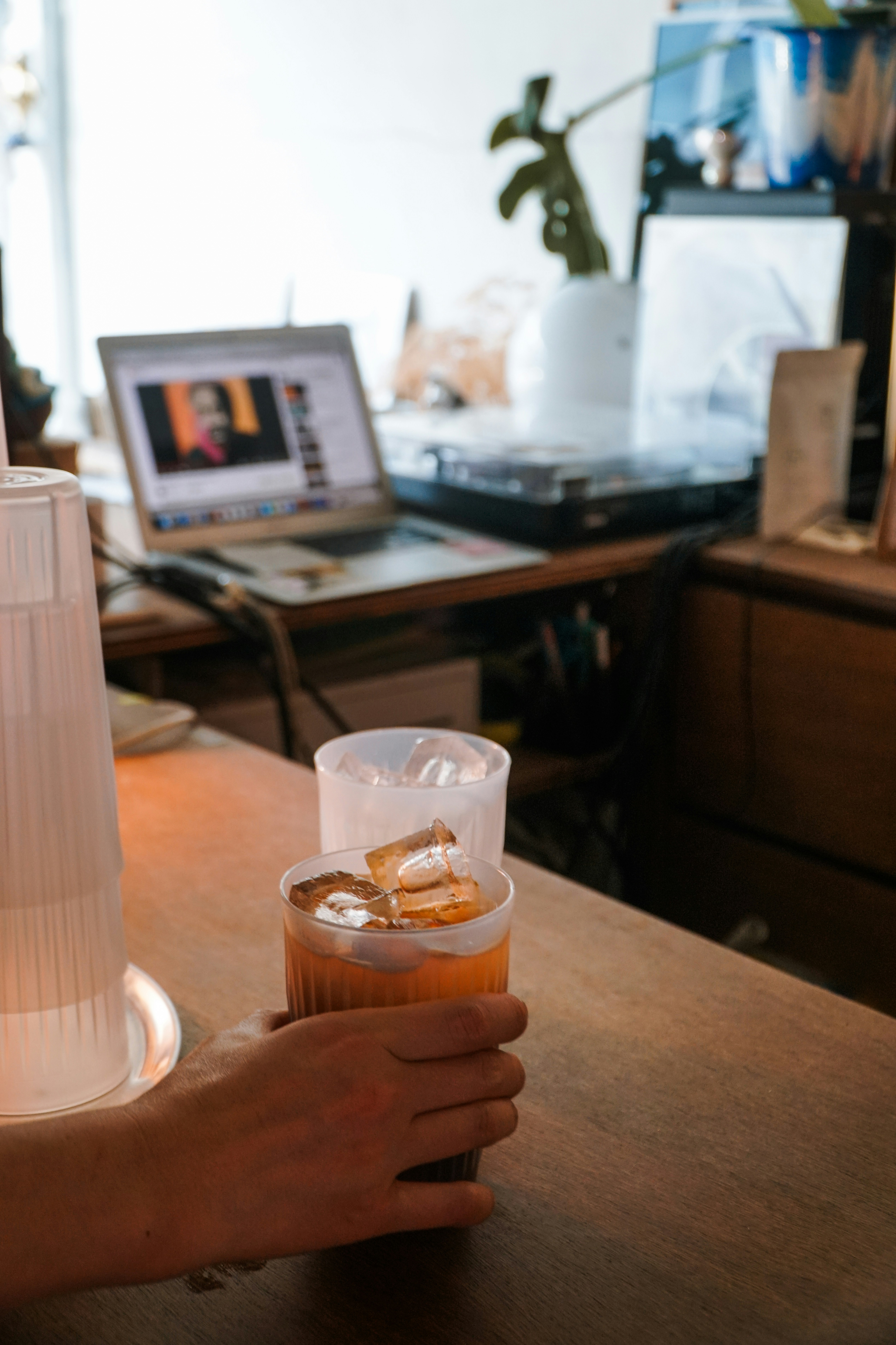 a person is holding a drink in their hand