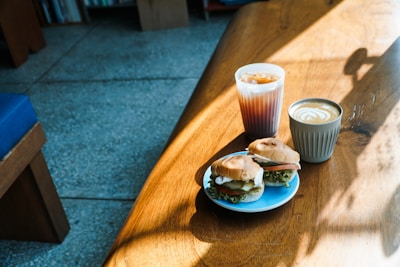 A cozy wooden table with a variety of homemade sandwiches and fresh ingredients.