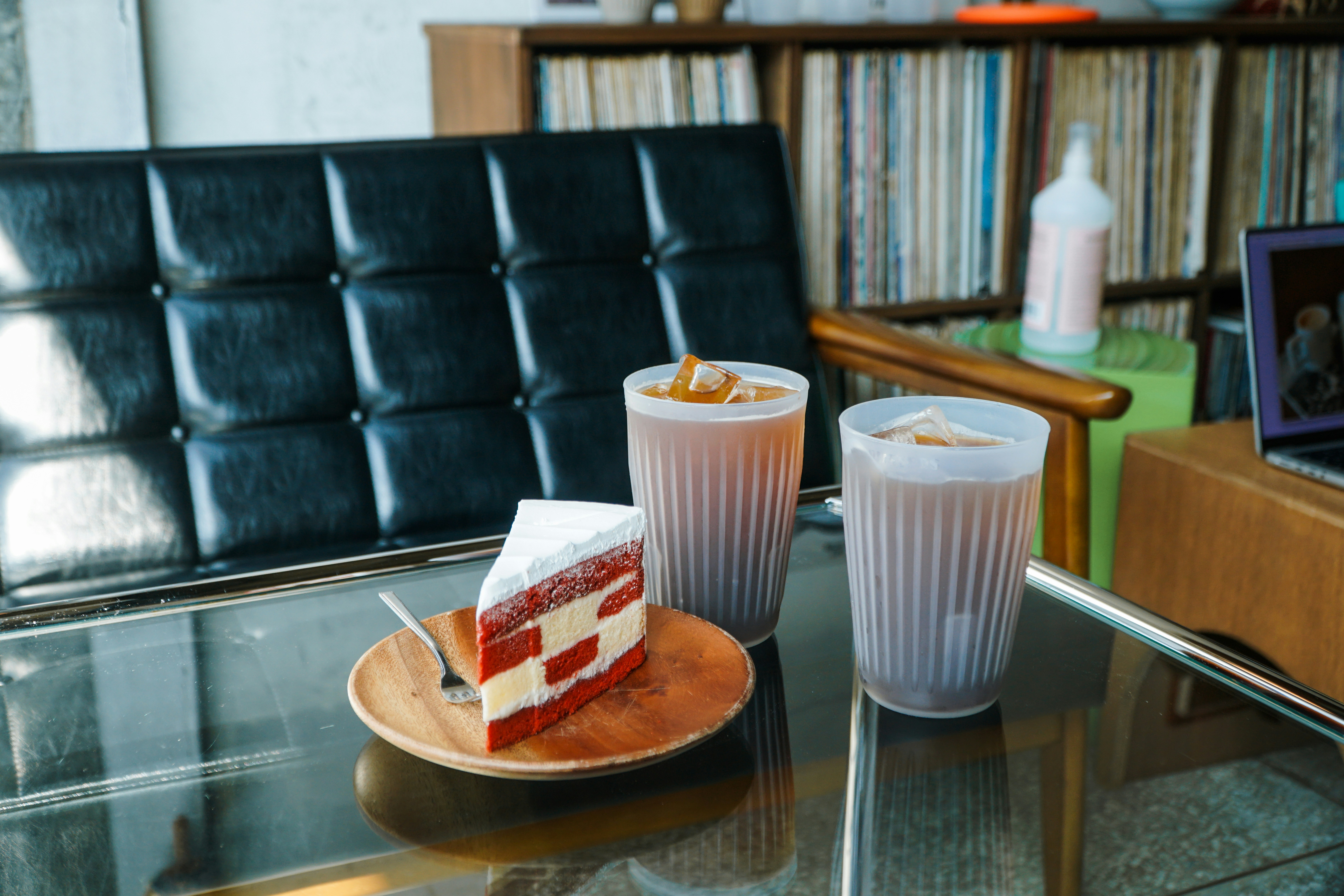 a slice of cake on a plate next to two cups