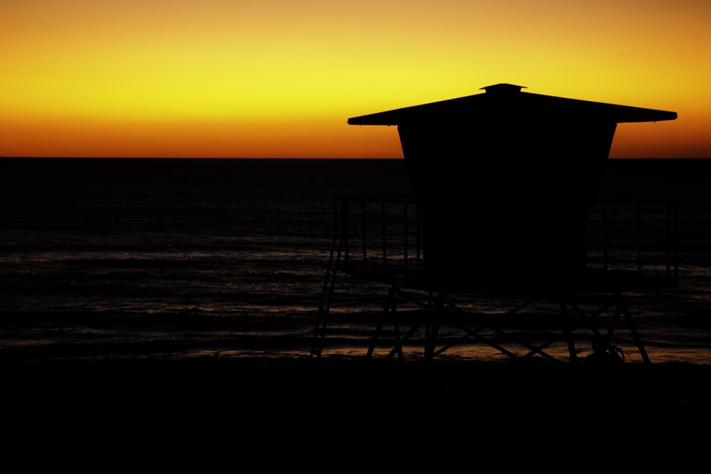 a lifeguard tower sitting on top of a beach next to the ocean