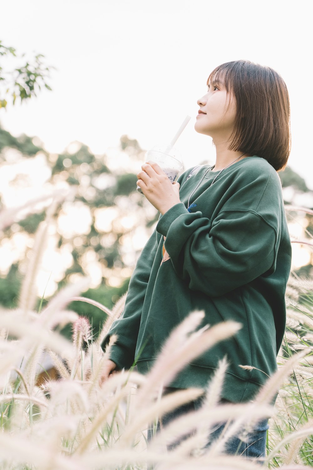 a woman standing in a field of tall grass