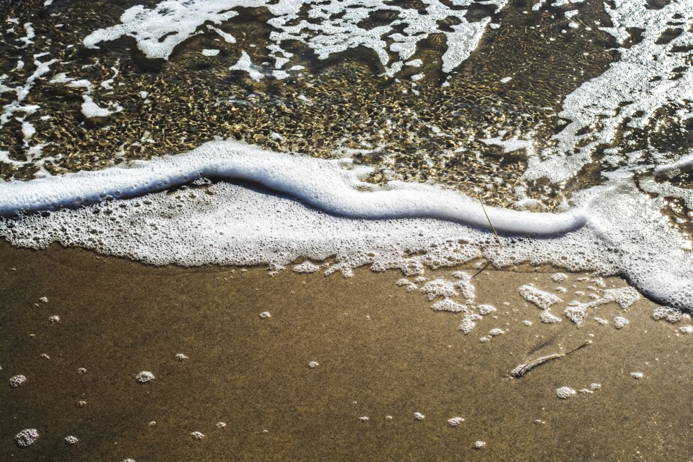 a wave coming in to the shore of a beach