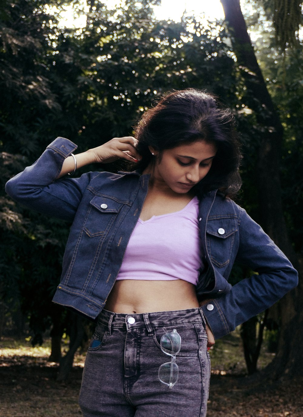 a woman in a crop top and jean jacket