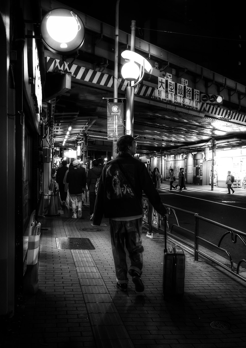 Un hombre caminando por una estación de tren con una maleta en la mano