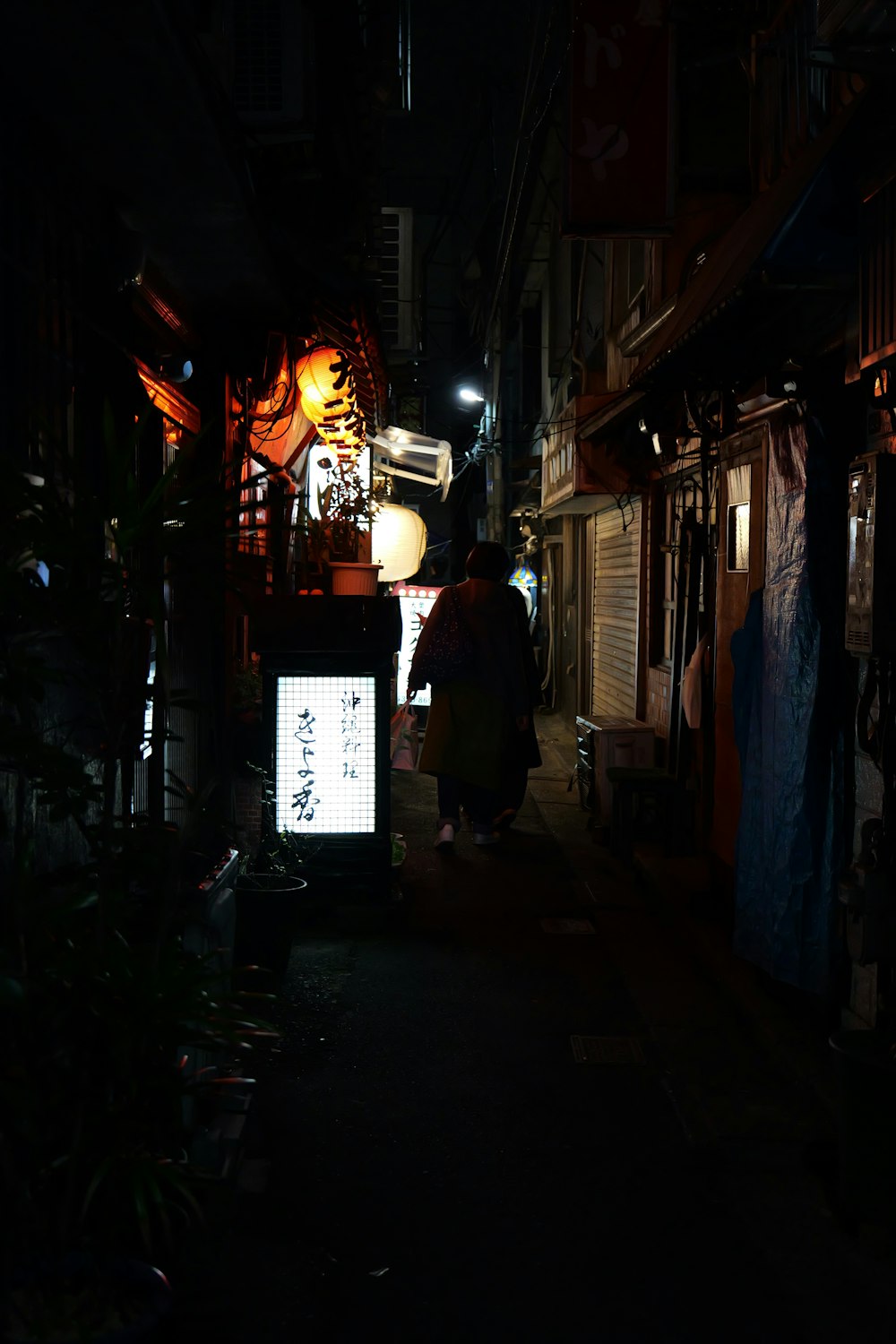 a person walking down a street at night