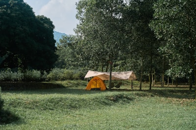 A cozy campsite with a large tent set up in a forest clearing.