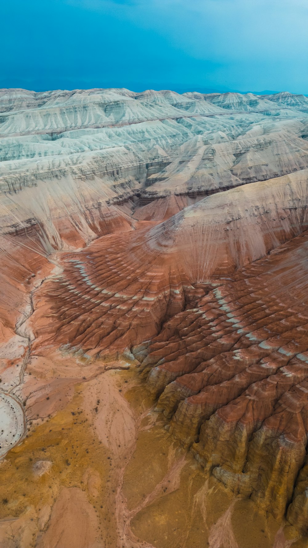 an aerial view of a desert landscape with a blue sky