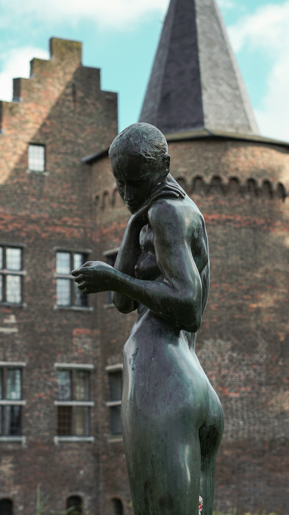 a statue of a woman holding a bird in front of a building