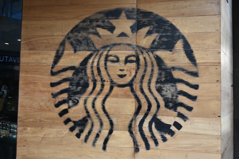 a starbucks sign painted on a wooden wall