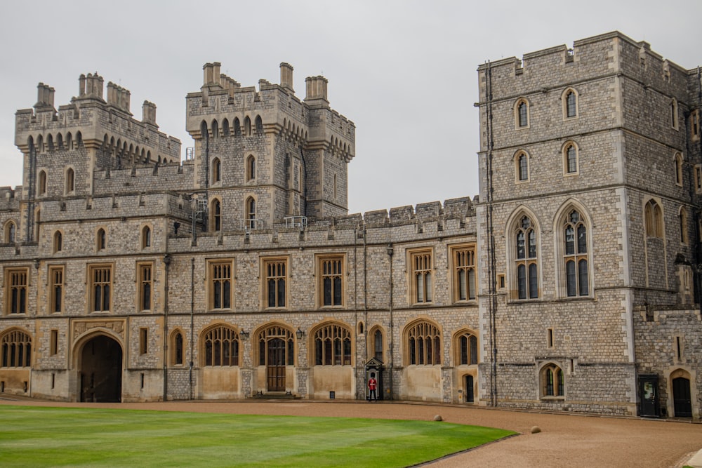 a large castle with a green lawn and a walkway