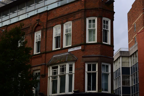 Red brick building with a glass roof and bay windows in Leicester city centre in autumn