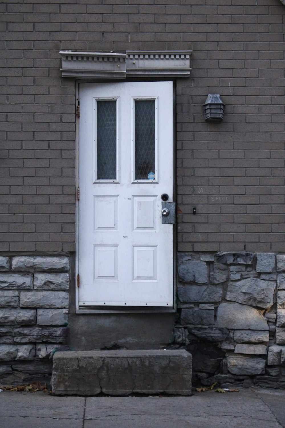 uma porta branca sentada ao lado de um prédio de tijolos