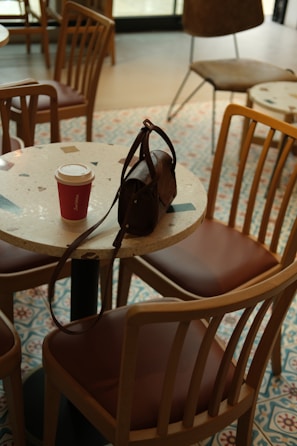 A cozy corner in a local café with women chatting over coffee and notebooks.