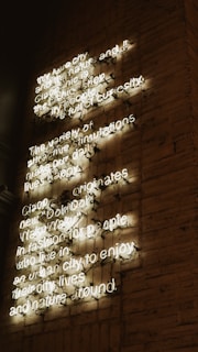 An artistic neon logo displayed on a brick wall, blending vintage texture with modern light.