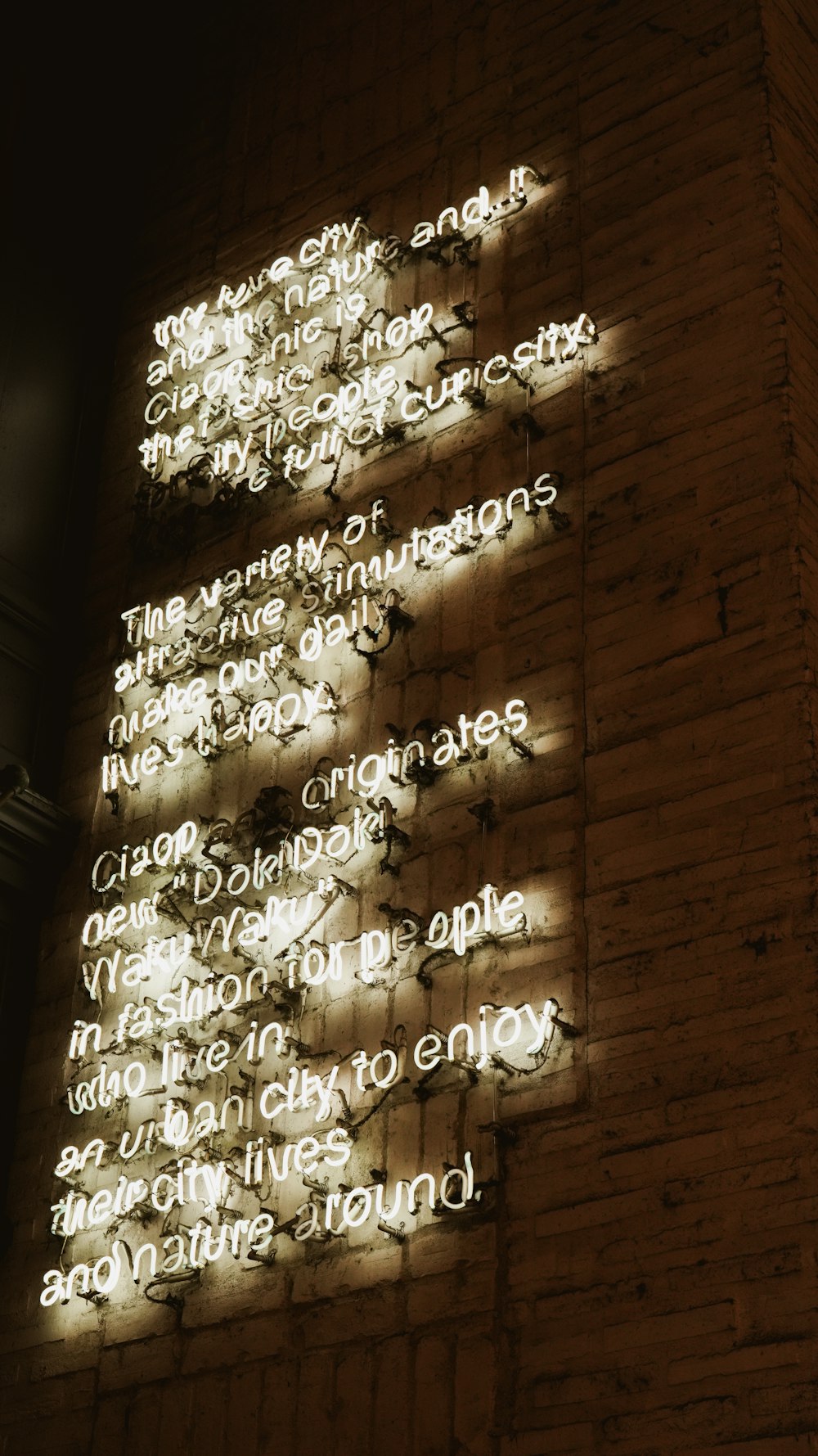 una pared de ladrillo con un letrero iluminado