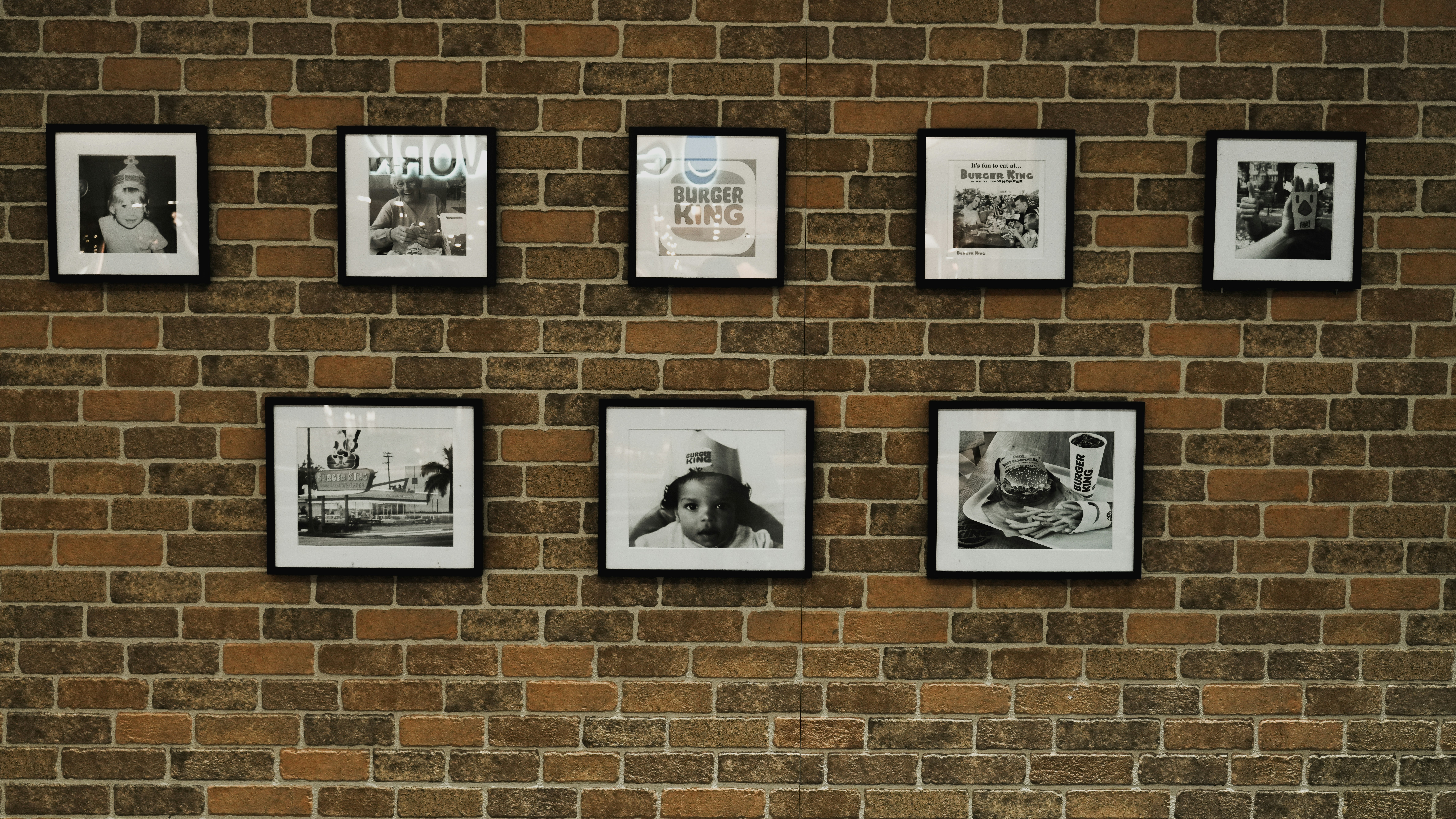 A brick wall with a bunch of pictures on it