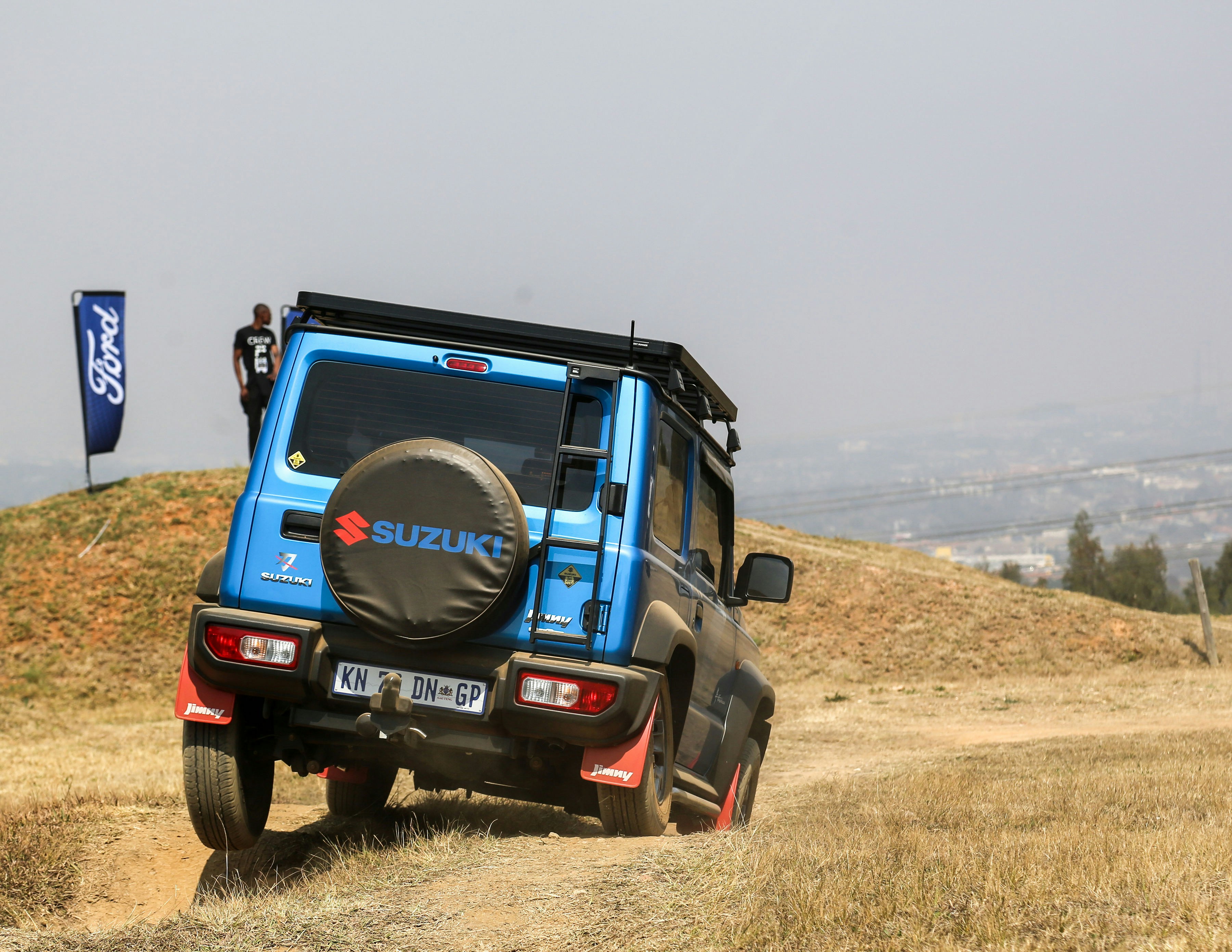 a blue truck driving down a dirt road
