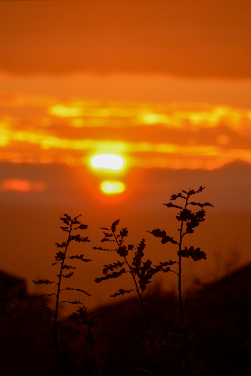 the sun is setting over a mountain range