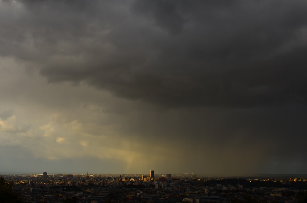 a dark cloud hovers over a cityscape